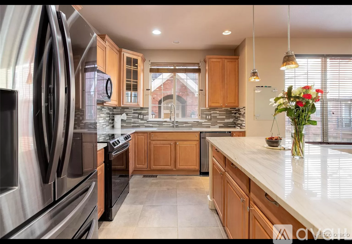 A kitchen with wooden cabinets and a black refrigerator.