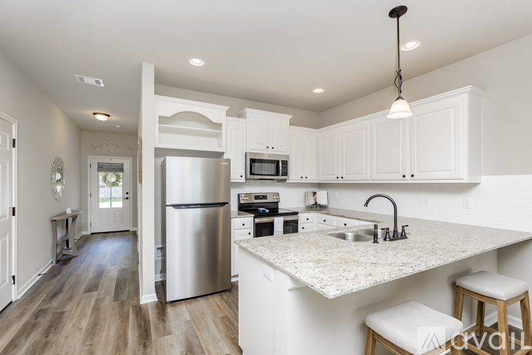 A kitchen with white cabinets and a granite countertop.