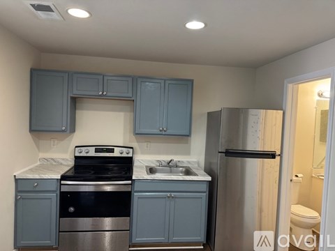 A kitchen with blue cabinets and stainless steel appliances.