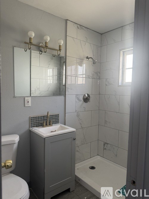 A bathroom with a toilet, sink, and shower.