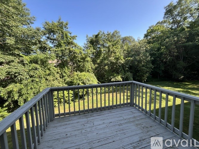 A deck with a railing overlooking a grassy area.