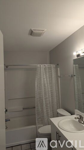 A bathroom with a toilet, sink, and shower.