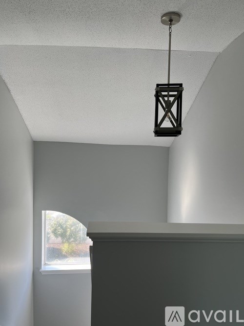 A black lantern hanging from the ceiling in a room.