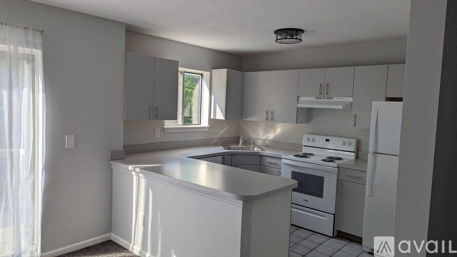 A kitchen with white appliances and cabinets is available for rent.
