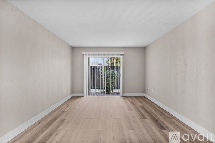 A room with wooden flooring and a window with bars on it.