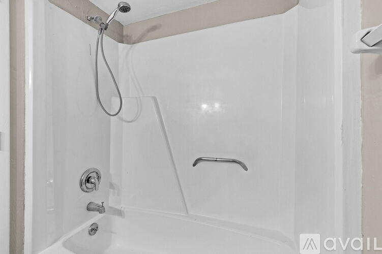 A white bathtub with a shower head and a faucet.