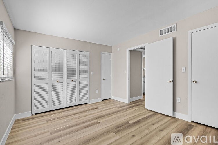 A room with white doors and a wooden floor.