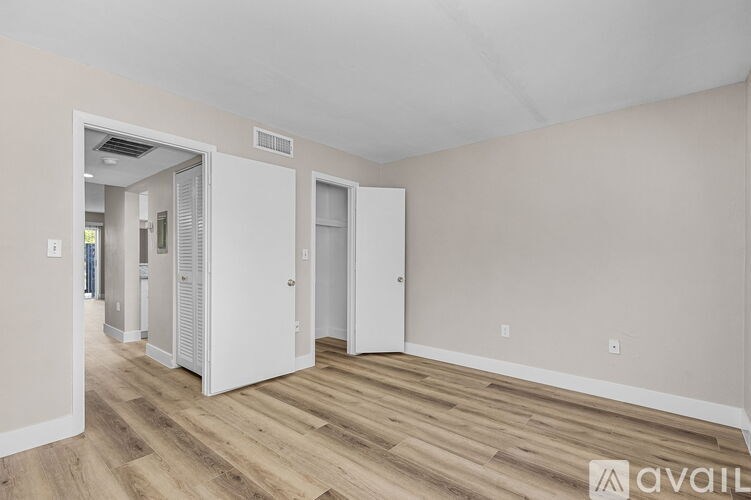 A room with wooden floors and white walls is available for rent.