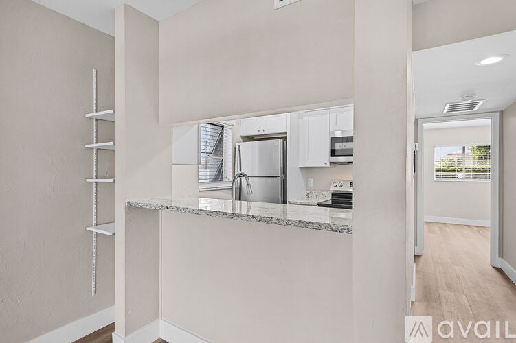 A modern kitchen with a marble countertop and stainless steel appliances.