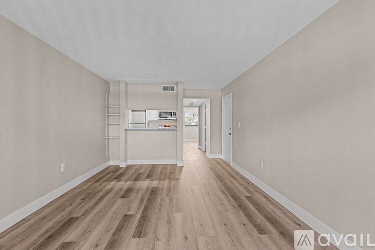 A room with wooden flooring and white walls.