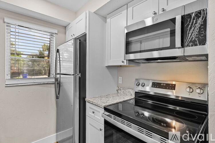 A kitchen with a stainless steel refrigerator, microwave, and oven.