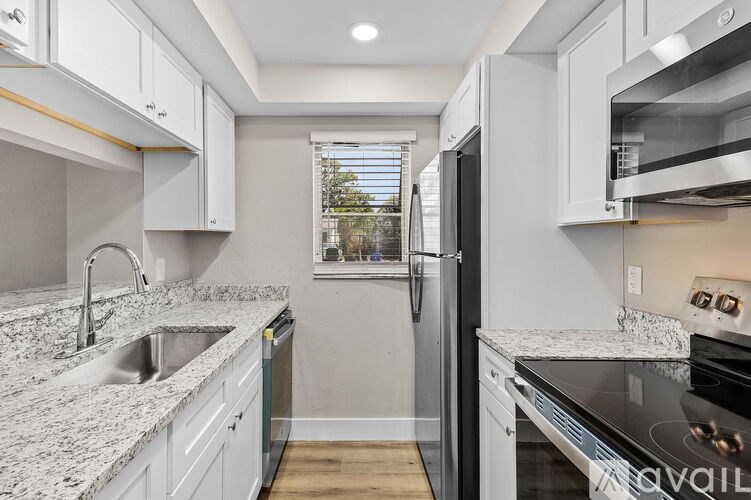 A kitchen with a granite countertop and stainless steel appliances.