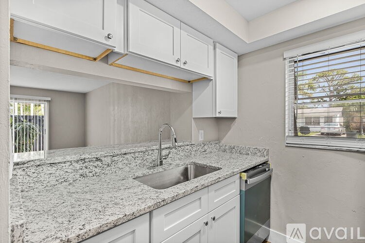 A kitchen with granite countertops and white cabinets.