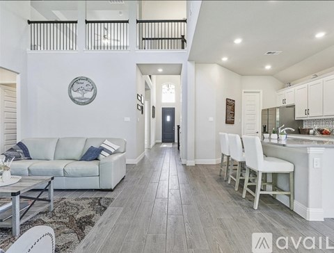 A modern living room with a white couch and a wooden floor.