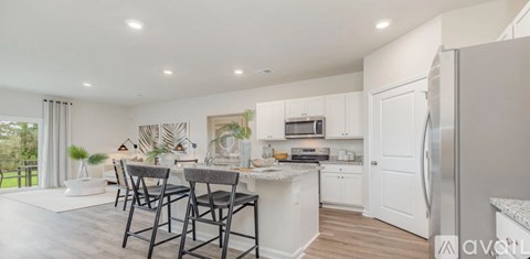 A modern kitchen with white cabinets and a large island.