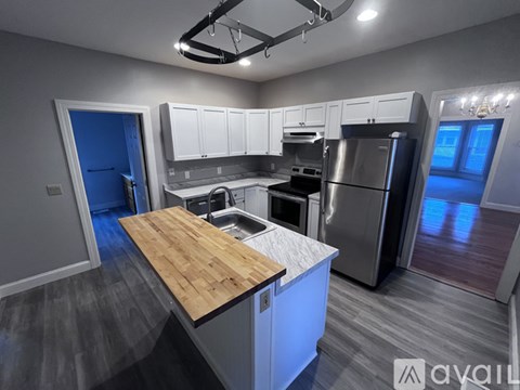 A modern kitchen with a wooden countertop and stainless steel appliances.