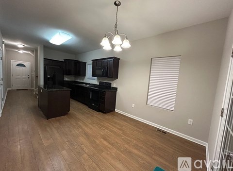 A well-lit kitchen with dark wood cabinets and a wooden floor.