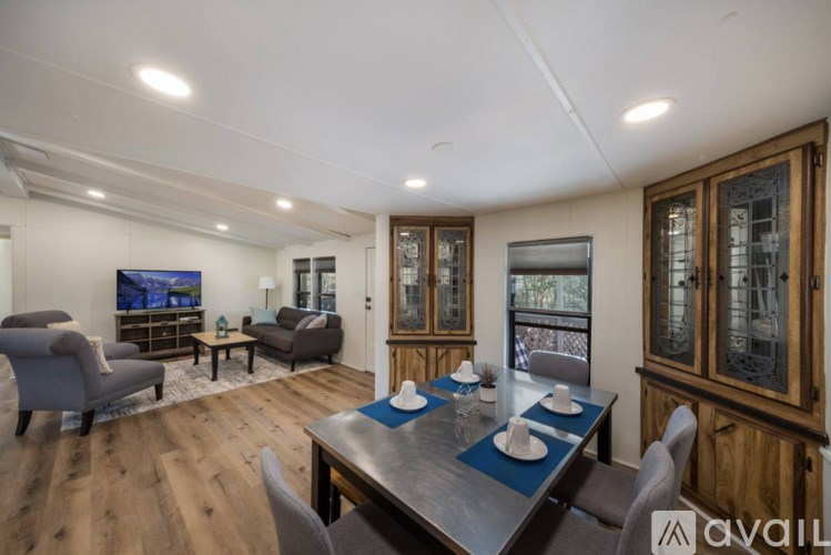 A modern dining room with a wooden table and chairs.