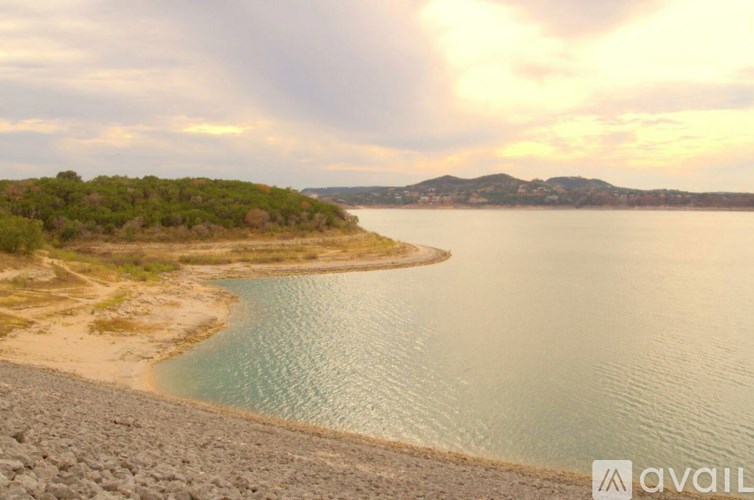 A beach with a body of water and a mountain in the distance.