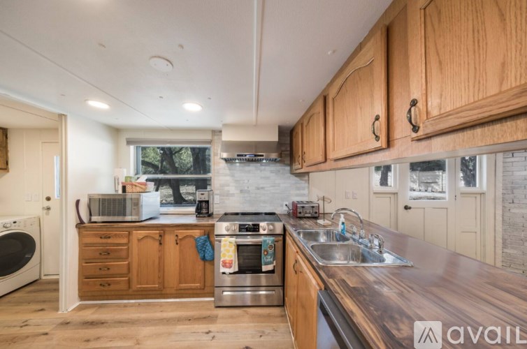 A kitchen with wooden cabinets and a dark counter top.
