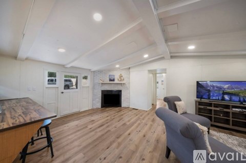 A living room with a fireplace and a television on the wall.