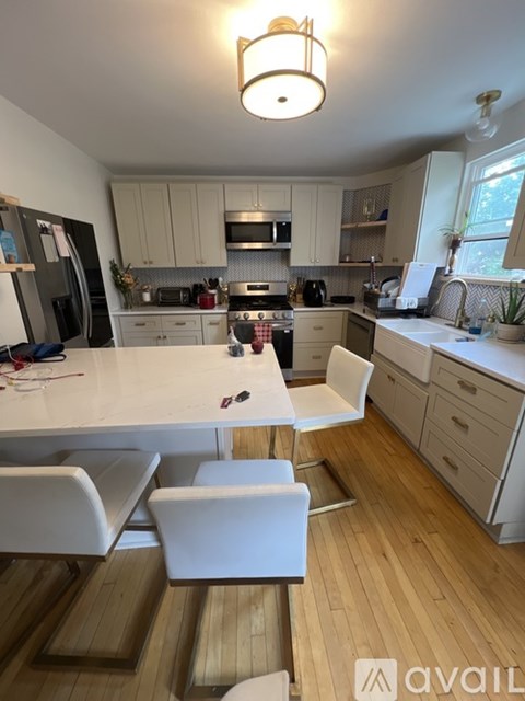 A kitchen with a table and chairs in the foreground and a refrigerator in the background.