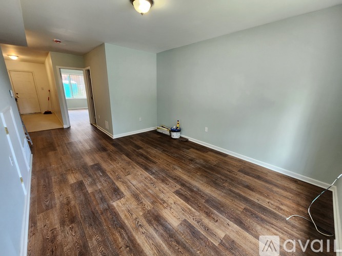 A room with wooden flooring and a white wall.
