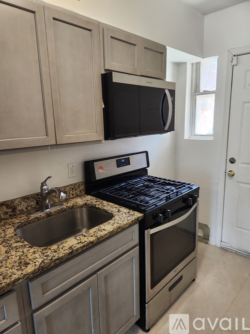 A kitchen with granite countertops and a black stove top oven.