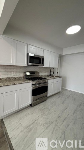 A kitchen with white cabinets and a granite countertop.