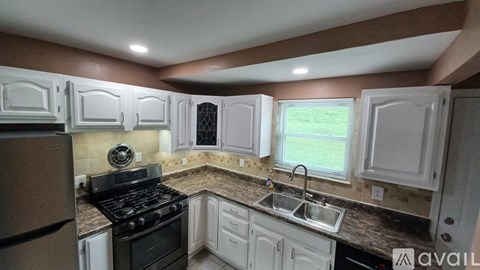A kitchen with white cabinets and a black stove top oven.