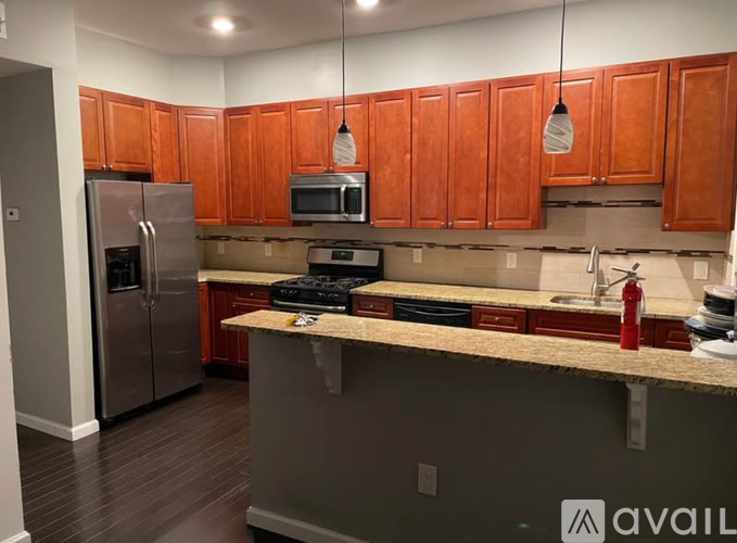 A kitchen with wooden cabinets and a stainless steel refrigerator.