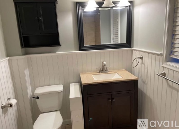 A bathroom with a toilet, sink, and medicine cabinet.