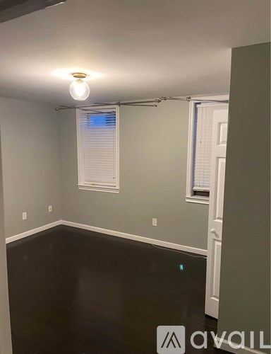 A room with a light on the ceiling and a window with blinds.