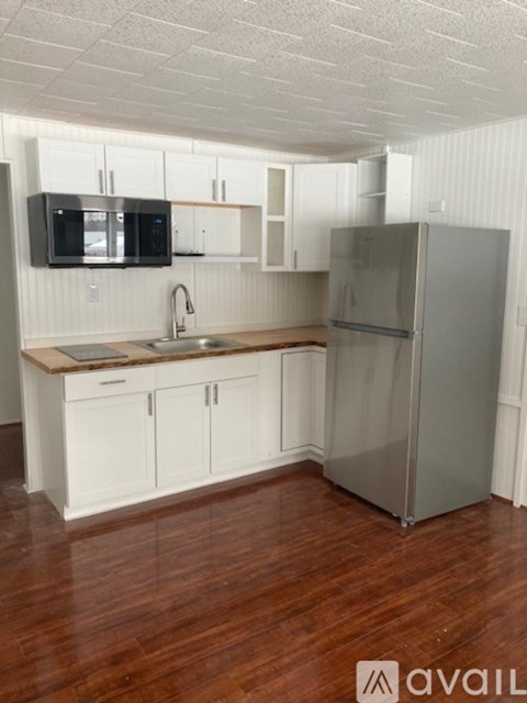 A kitchen with white cabinets and a wooden countertop.
