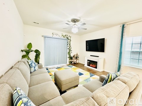 A living room with a large sectional sofa and a flat screen TV.
