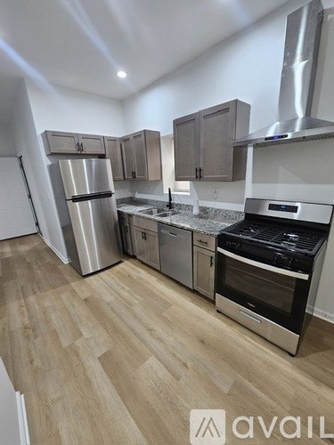 A kitchen with wooden floors and stainless steel appliances.