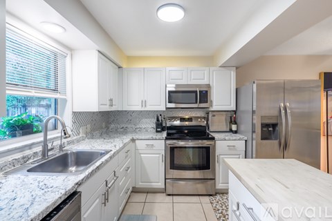 A kitchen with white cabinets and stainless steel appliances.