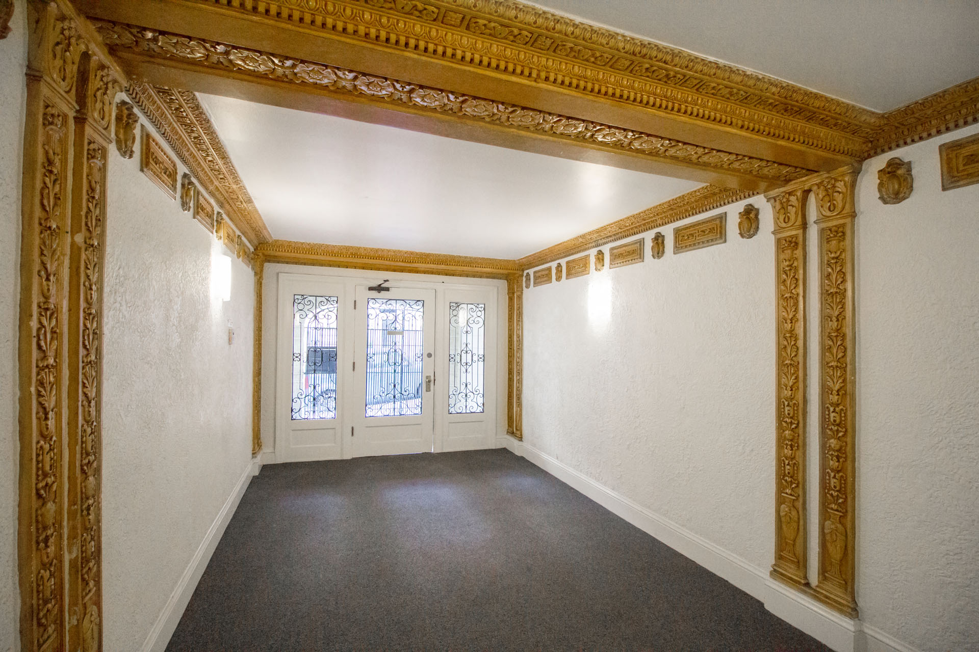 A room with a white wall and a doorway with a glass window.