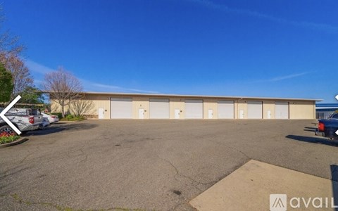 A parking lot with a building and a car parked in front.