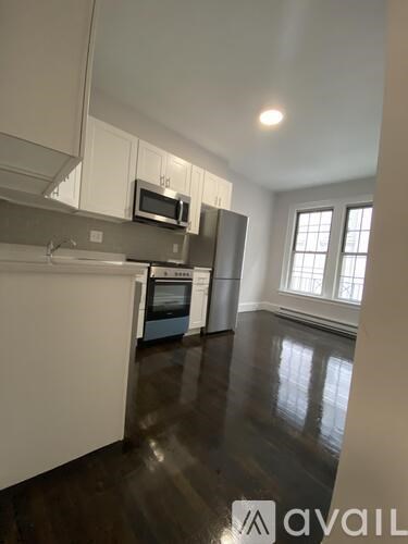 A kitchen with white cabinets and a microwave above the oven.