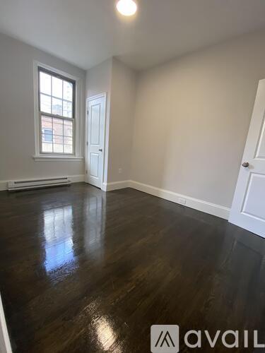 A room with wooden floors and two white doors.