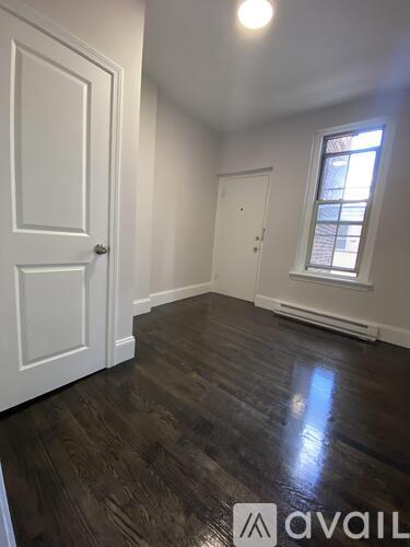 A room with wooden floors and two doors.