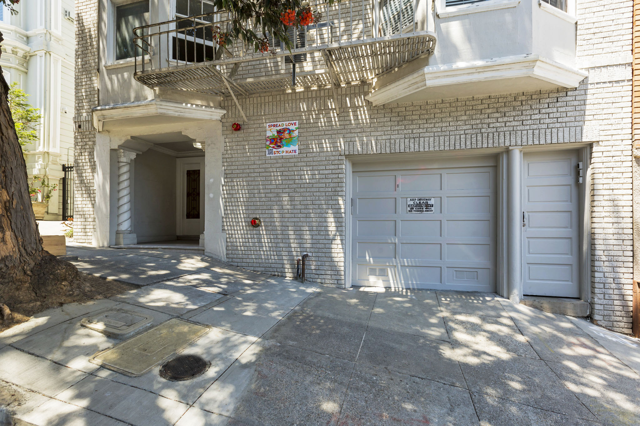 A white building with a balcony and a sign on the wall.