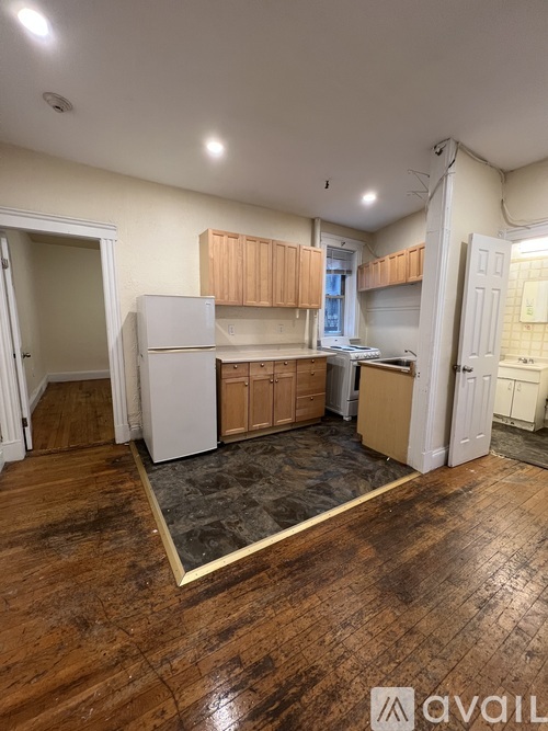 A kitchen with wooden floors and white appliances.