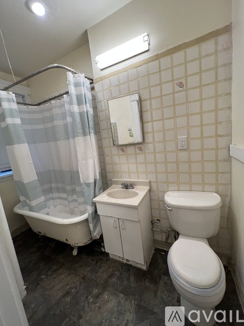 A bathroom with a toilet, sink, and shower.