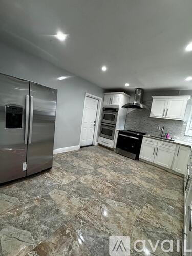 A kitchen with a refrigerator, oven, and cabinets.