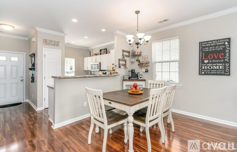 A kitchen with a dining table and chairs.