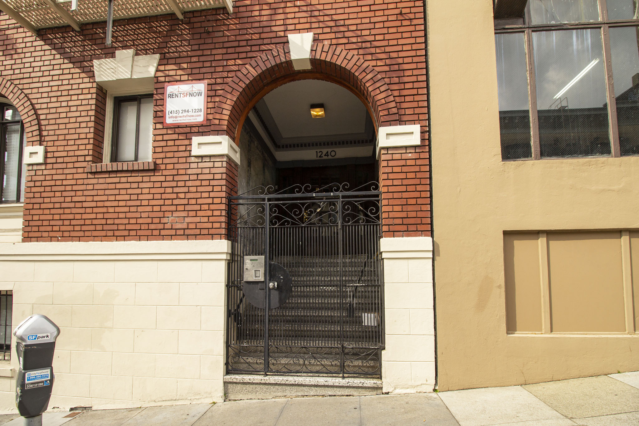 A black gate with a sign above it that says "No Parking".