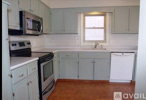 A kitchen with white cabinets and a black stove top oven.