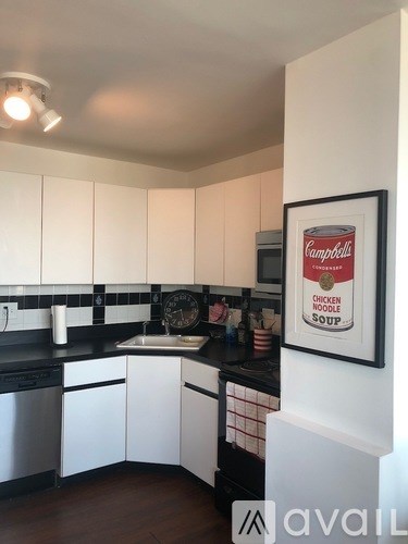 A kitchen with a framed picture of Campbell's Chicken Noodle Soup on the wall.